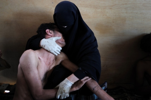 2011: Μια γυναίκα κρατά συγγενή της σε ένα αυτοσχέδιο νοσοκομείο σε τζαμί της Υεμένης.