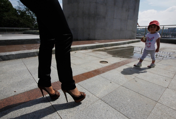 Μια γυναίκα παίρνει το παιδί της για μια βόλτα κοντά σε ένα μνημείο στο Βλαδιβοστόκ, Ρωσία
