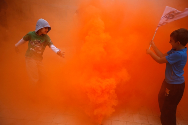 Αγόρια παίζουν με ένα δοχείο καπνού κατά τη διάρκεια διαδήλωσης από τους πυροσβέστες, την ασφάλεια και το στρατιωτικό προσωπικό ενάντια στις περικοπές των μισθών που τους επιβλήθηκαν  από την ισπανική κυβέρνηση, στην πρωτεύουσα της Ανδαλουσίας της Σεβίλλης